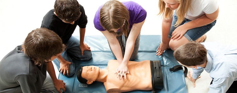 A group of people watching one of them perform first aid