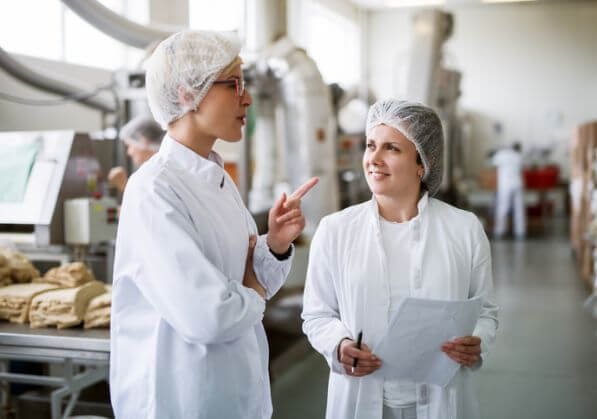 Two people supervising food safety in a kitchen
