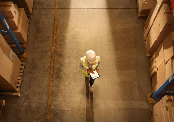 A Lone Worker in a warehouse using a tablet