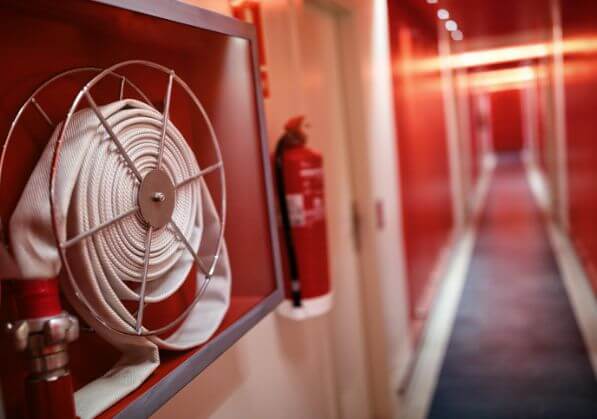 Fire extinguisher and fire hose in a corridor