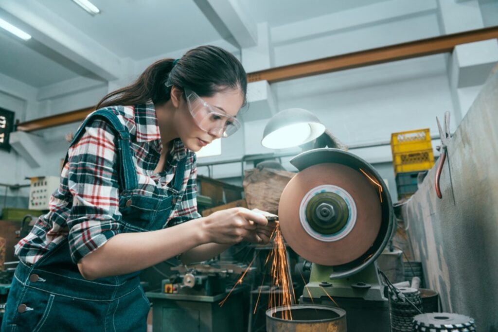 Woman using an abrasive wheel in a workshop