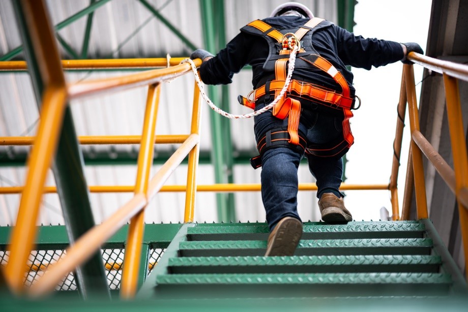 Working at height climbing a ladder with a harness